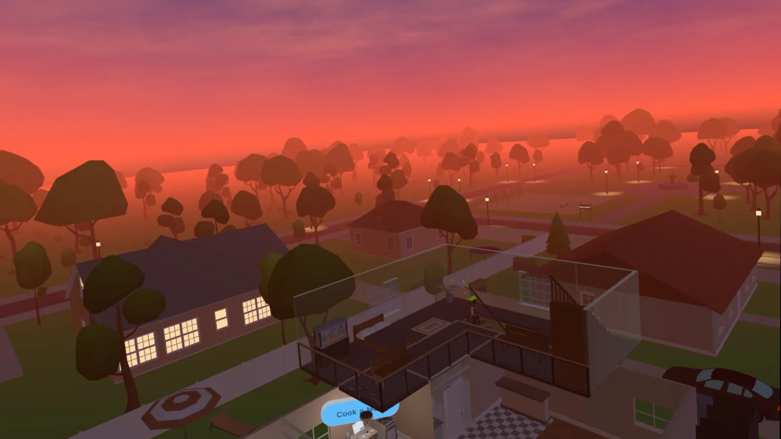 A sunset over Derville, with lit windows, trees and a view into the Vicarious home